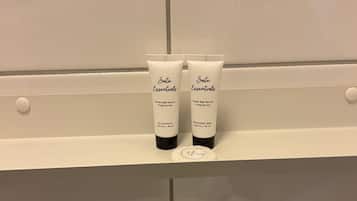 Two toiletry items on a white shelf in a bathroom.