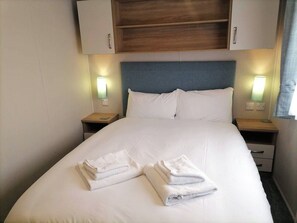 Ein Hotelzimmer mit einem Bett, zwei Nachttischen und einem hölzernen Kopfteil.