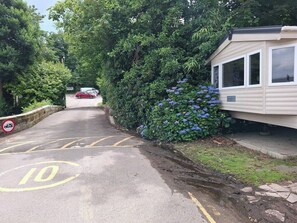 Eine Straße mit Geschwindigkeitsbegrenzungsschild, Parkplatz und einem Wohnwagen.