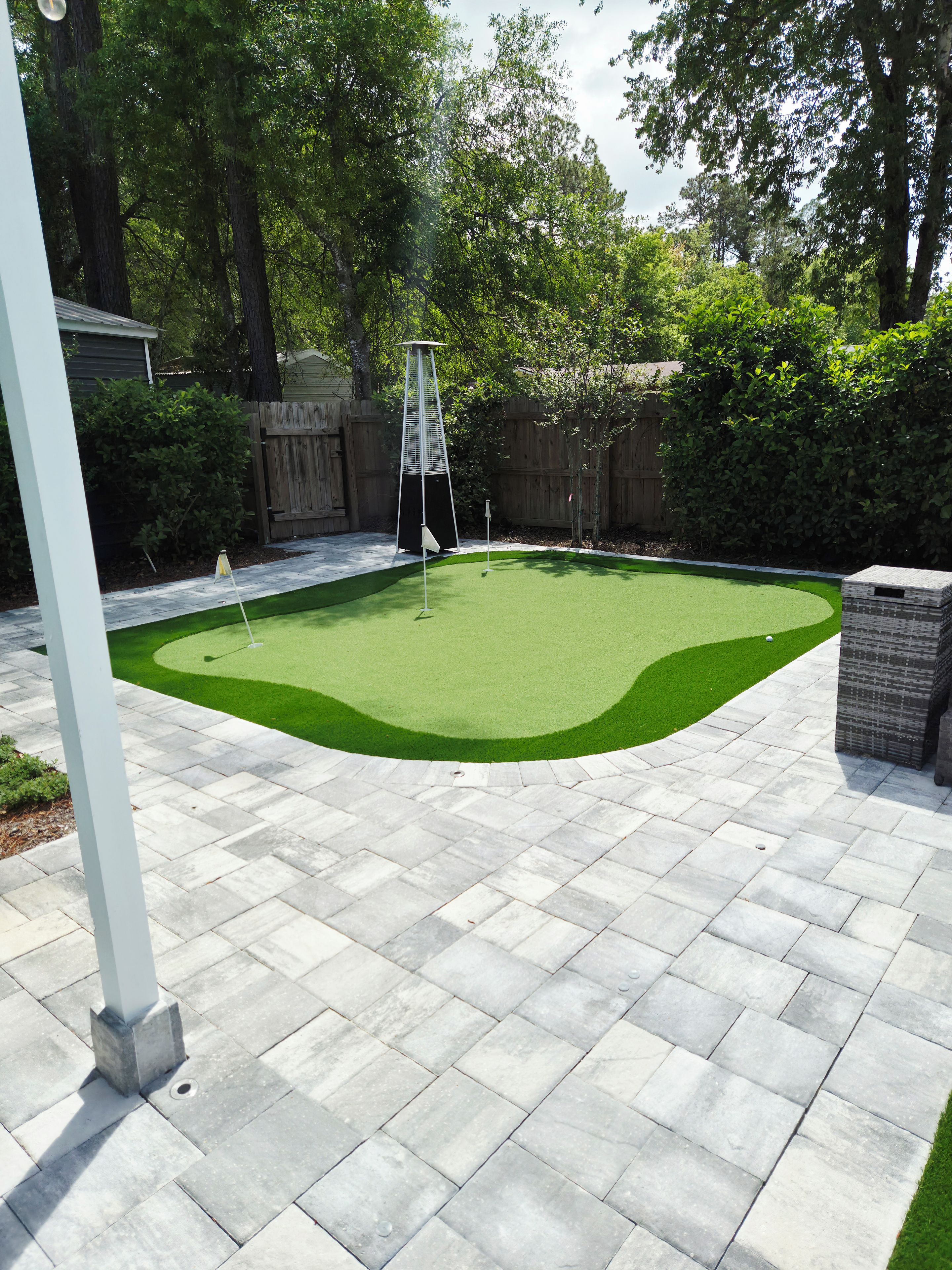 Un parcours de minigolf doté d’un tapis vert pour les putts, d’un mât de drapeau et d’une bordure en briques.