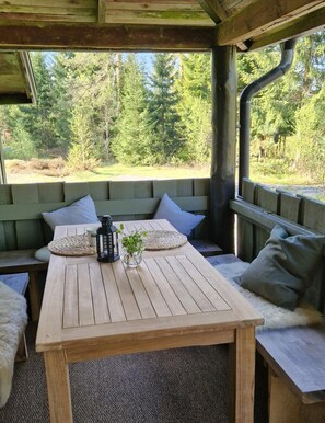 A wooden table with a bench, a lantern, and a small plant. - New Listing (45751 Bullaren)