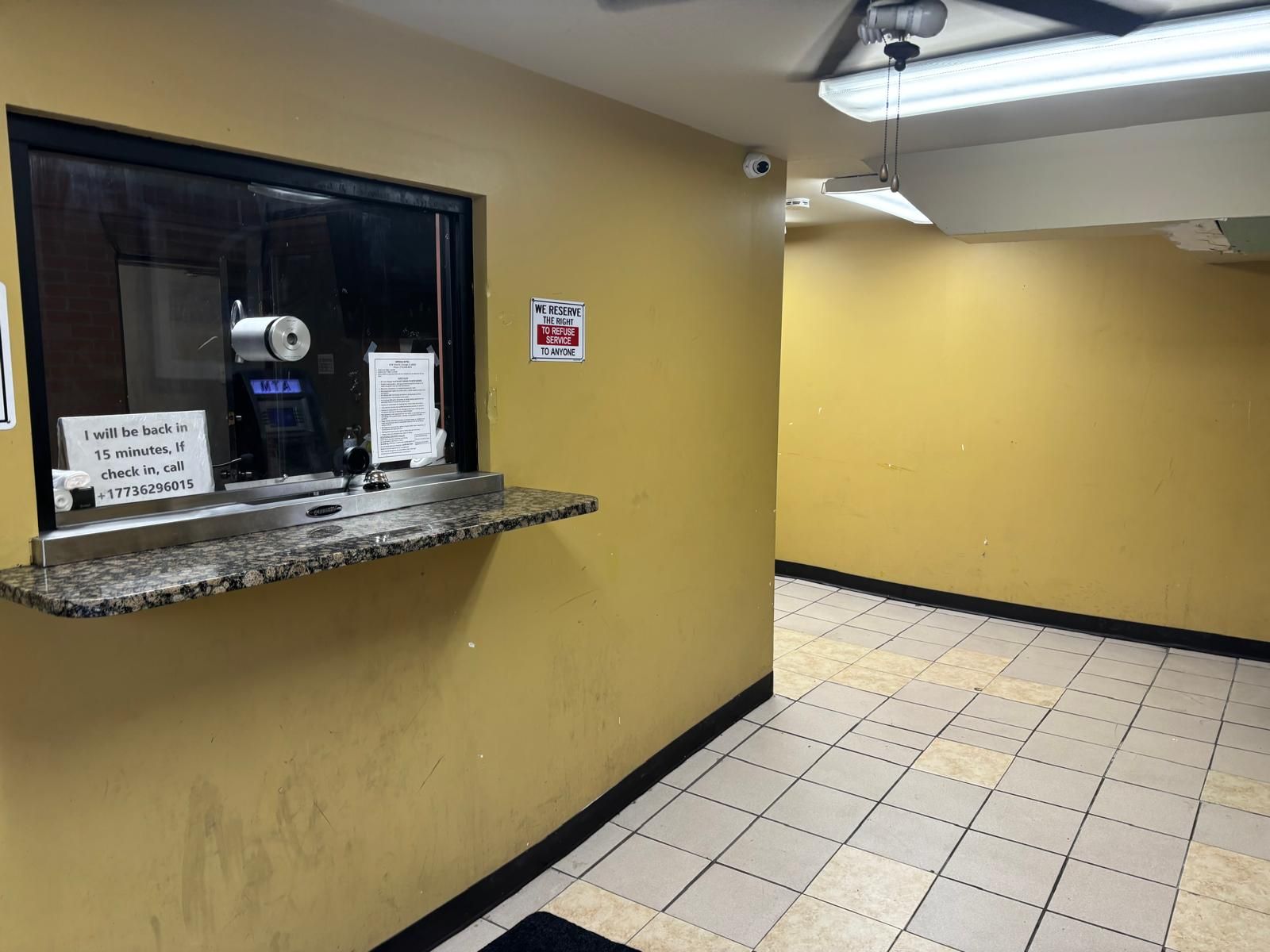 Un baño con un lavabo de mármol, un cartel que dice 'Nos reservamos el derecho de negarle el servicio a quien desee' y un cartel que indica 'Regresaré en 15 minutos, si el registro, llame'.