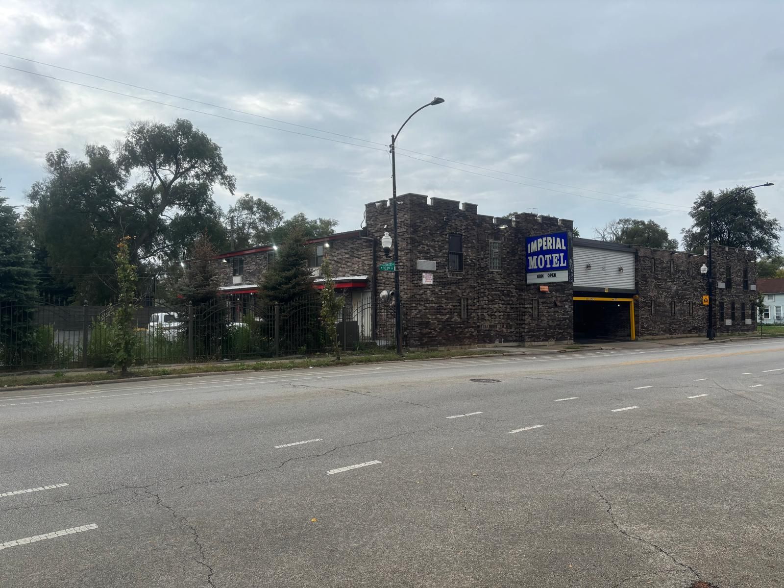 Un edificio de ladrillo con un letrero que dice 'Imperial Motel' y una puerta de garaje cerrada.