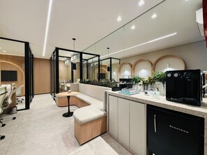 A modern kitchen with a coffee machine, a sink, and a countertop with various items. - O Melhor de Goiania! Apt de 1 Quarto no coracao do Marista (Goiânia)