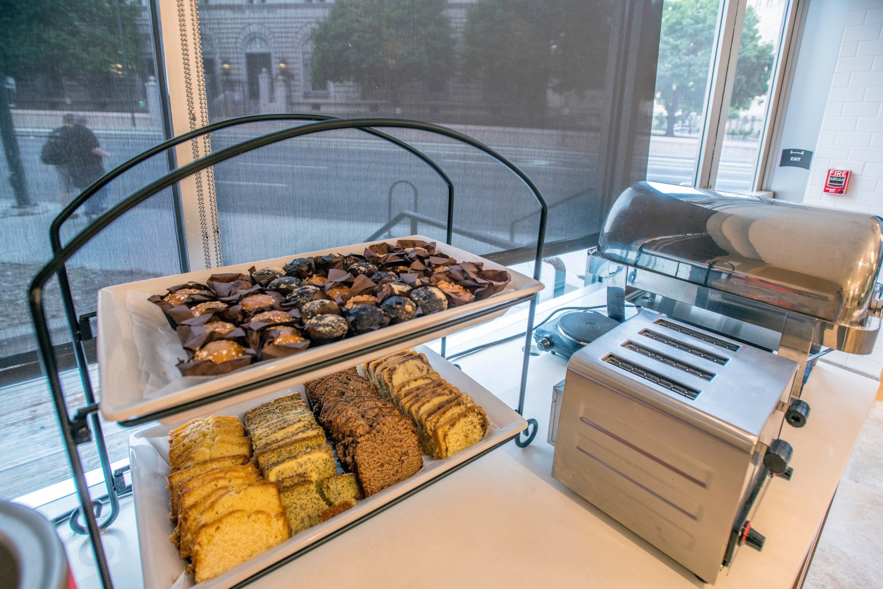 A buffet with various baked goods and a toaster.