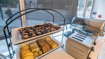 A buffet with various baked goods and a toaster.