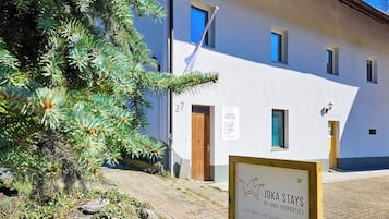 A building with a sign for JOKA STAYS BY JOKA PROPERTIES, indicating short-term rental apartments.