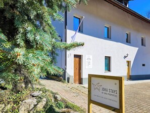 Un immeuble portant une enseigne indiquant « JOKA STAYS BY JOKA PROPERTIES », ce qui signifie qu’il propose des appartements en location de courte durée.