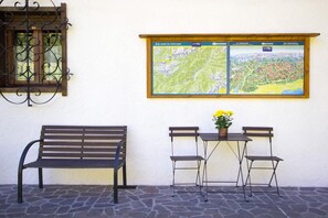 Um banco, uma mesa com cadeiras e um mapa na parede.