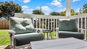 A deck with two chairs and a small table. - Sandy Shores (Galveston)