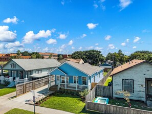 Un barrio residencial con casas, cerca de madera y una piscina pequeña.