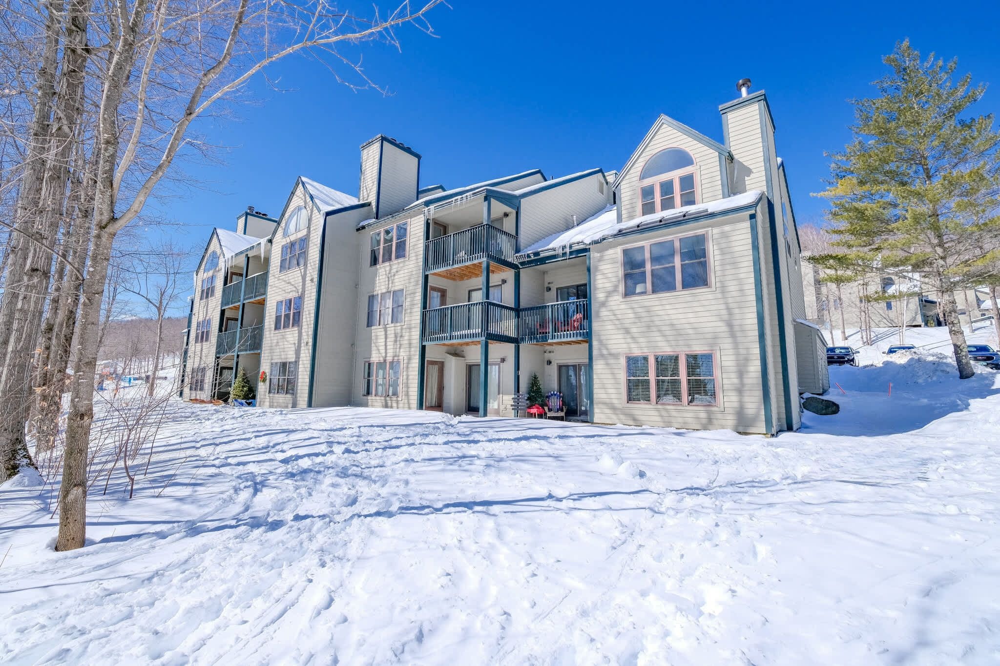 Un immeuble à plusieurs étages, doté de balcons et dont le sol est recouvert de neige.