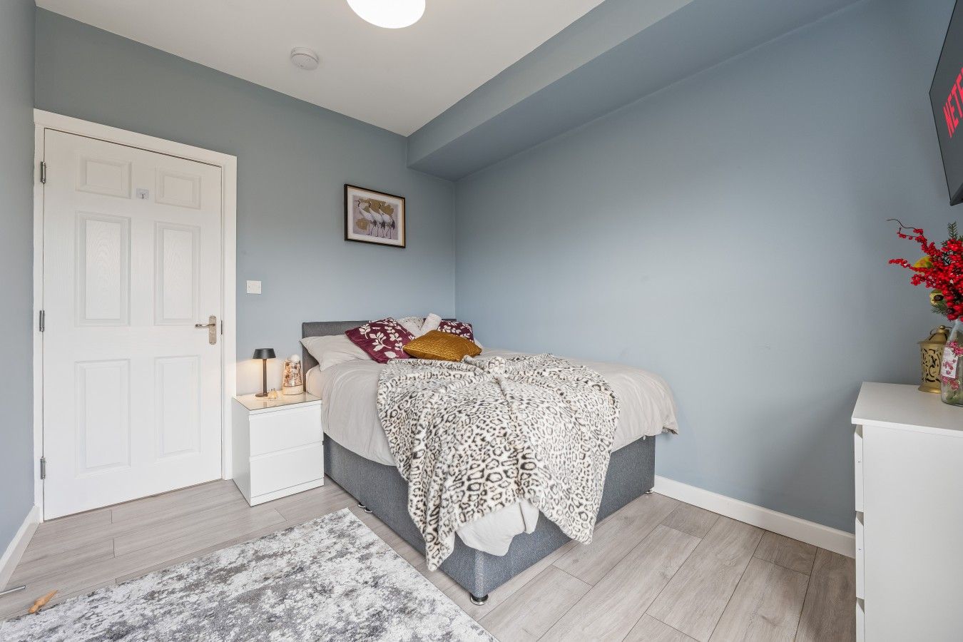 A bedroom with a bed, bedside table, and a nightstand.