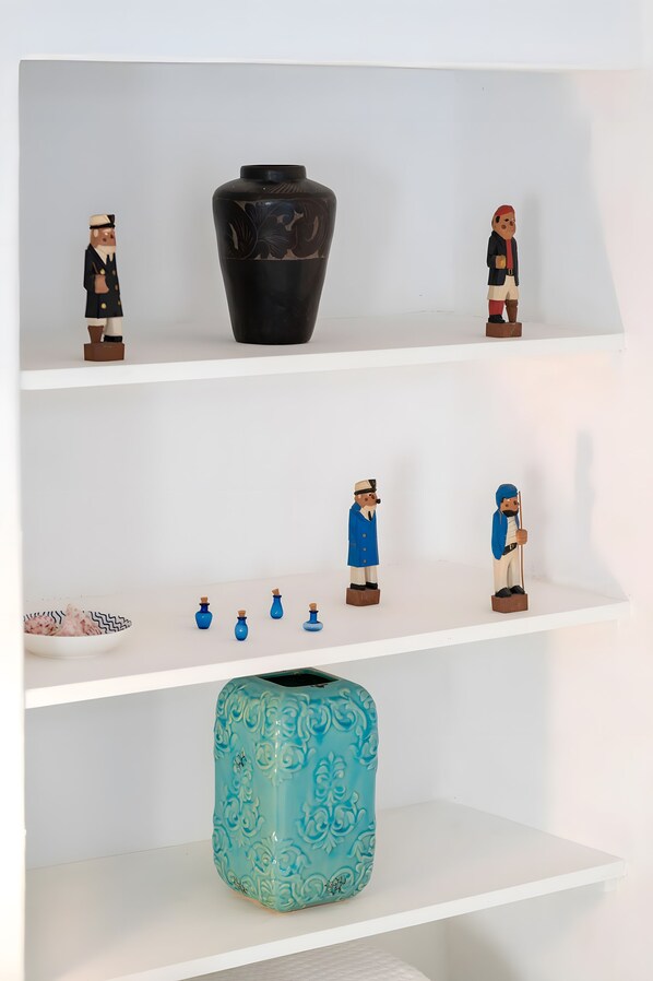 A white shelf with various objects including a black vase, figurines, and a blue patterned container. - Holiday Home 'Cantinho De São Miguel' with Wi-Fi and Air Conditioning (Alcácer do Sal)