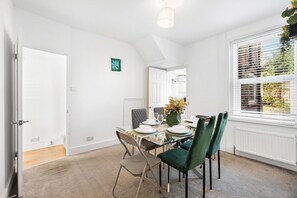 En matplats med ett glasbord, stolar och en vas med blommor.