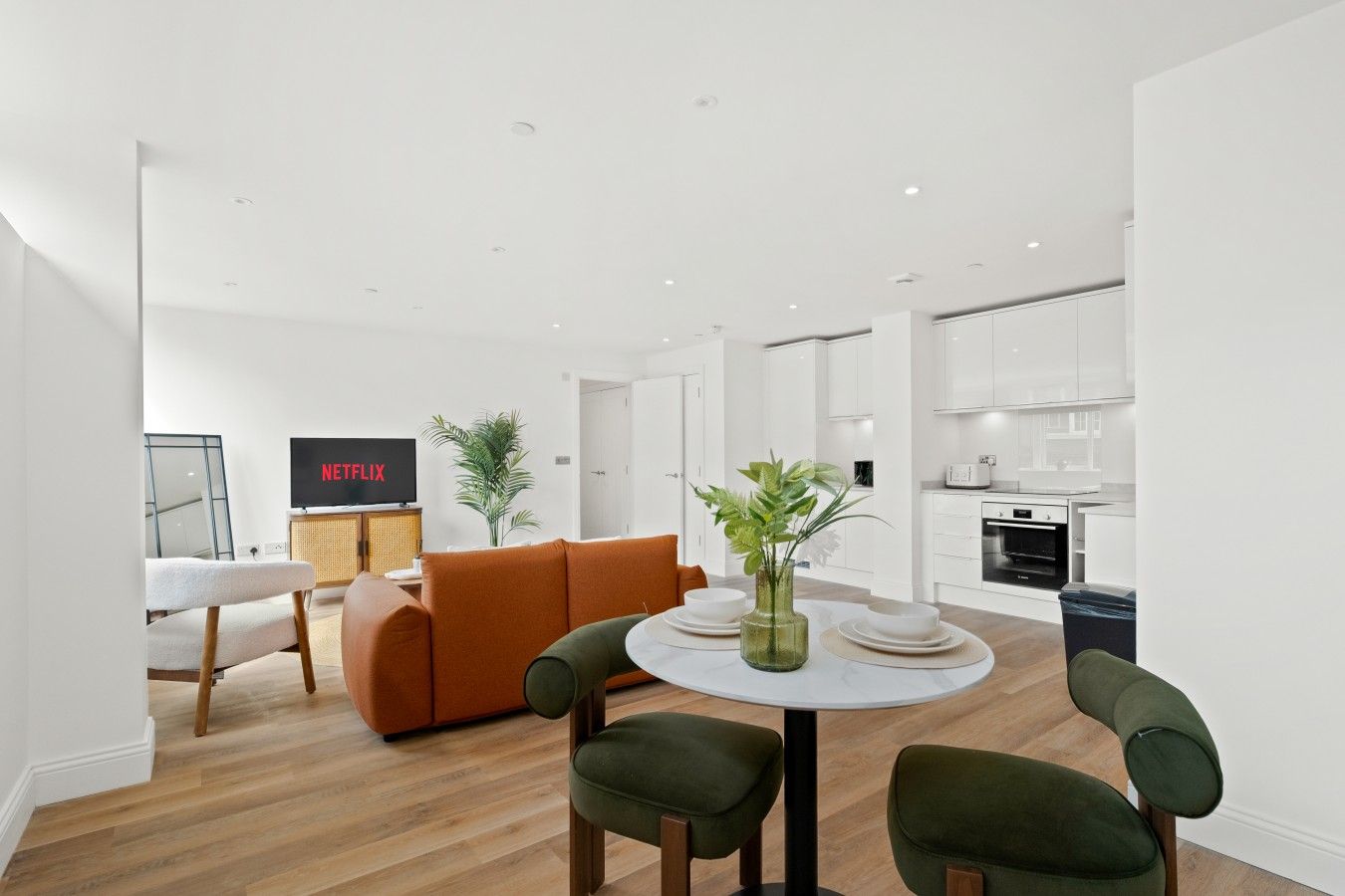 Uma sala de estar moderna com um sofá, uma mesa de centro e uma TV exibindo Netflix.