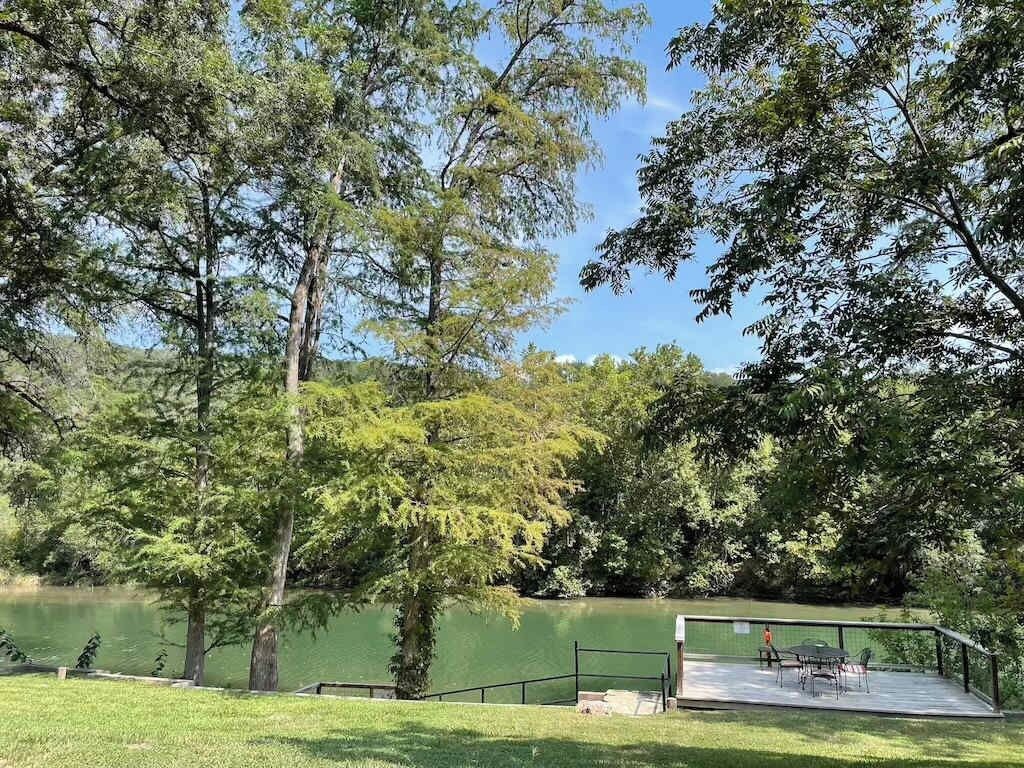 A lakeside park with a deck and chairs.