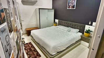 Una camera da letto con un letto, un comodino, un condizionatore d'aria a parete e una ventola a soffitto.
