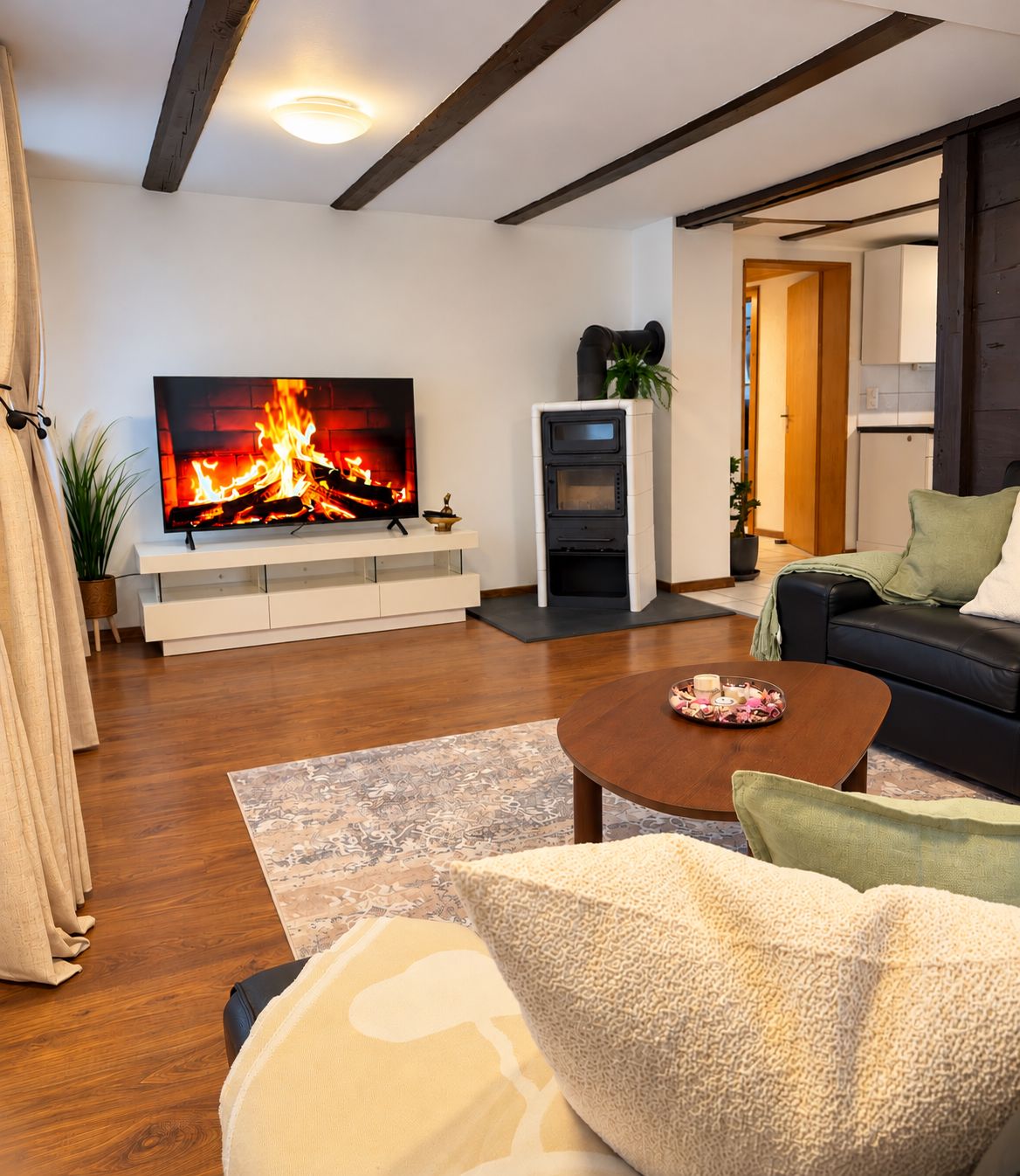 Een moderne woonkamer met een flatscreen televisie, een open haard, een bank en een salontafel.