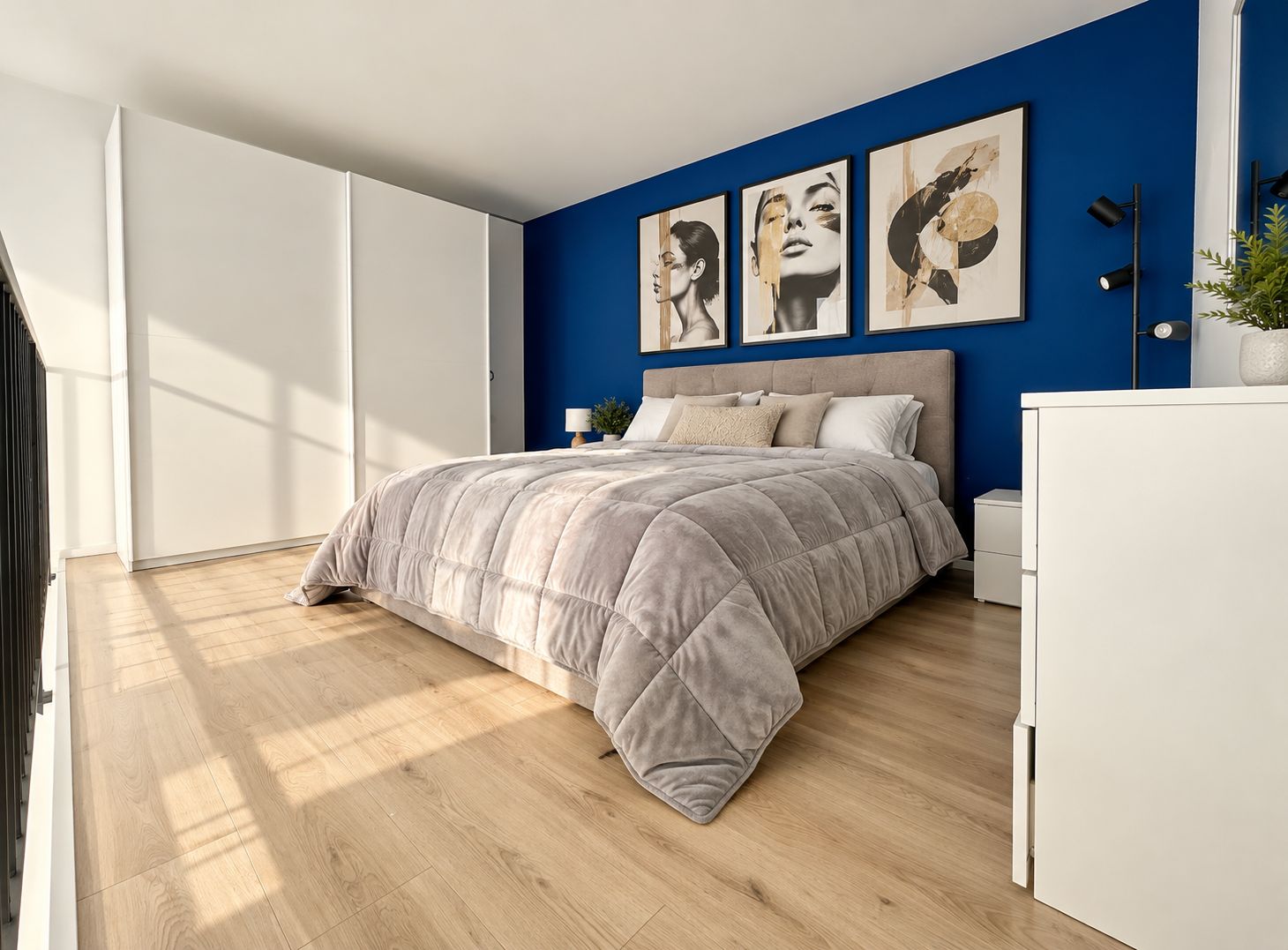 Un dormitorio con una cama, una mesita de noche, un aparador y un ventanal grande.