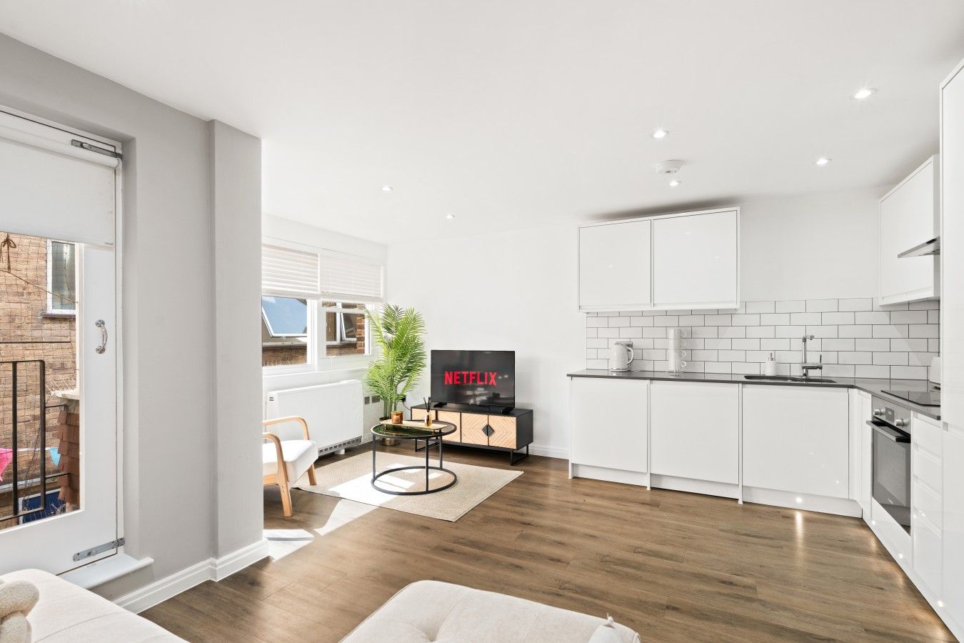 A modern kitchen with white cabinets, a black countertop, and a built-in oven.
