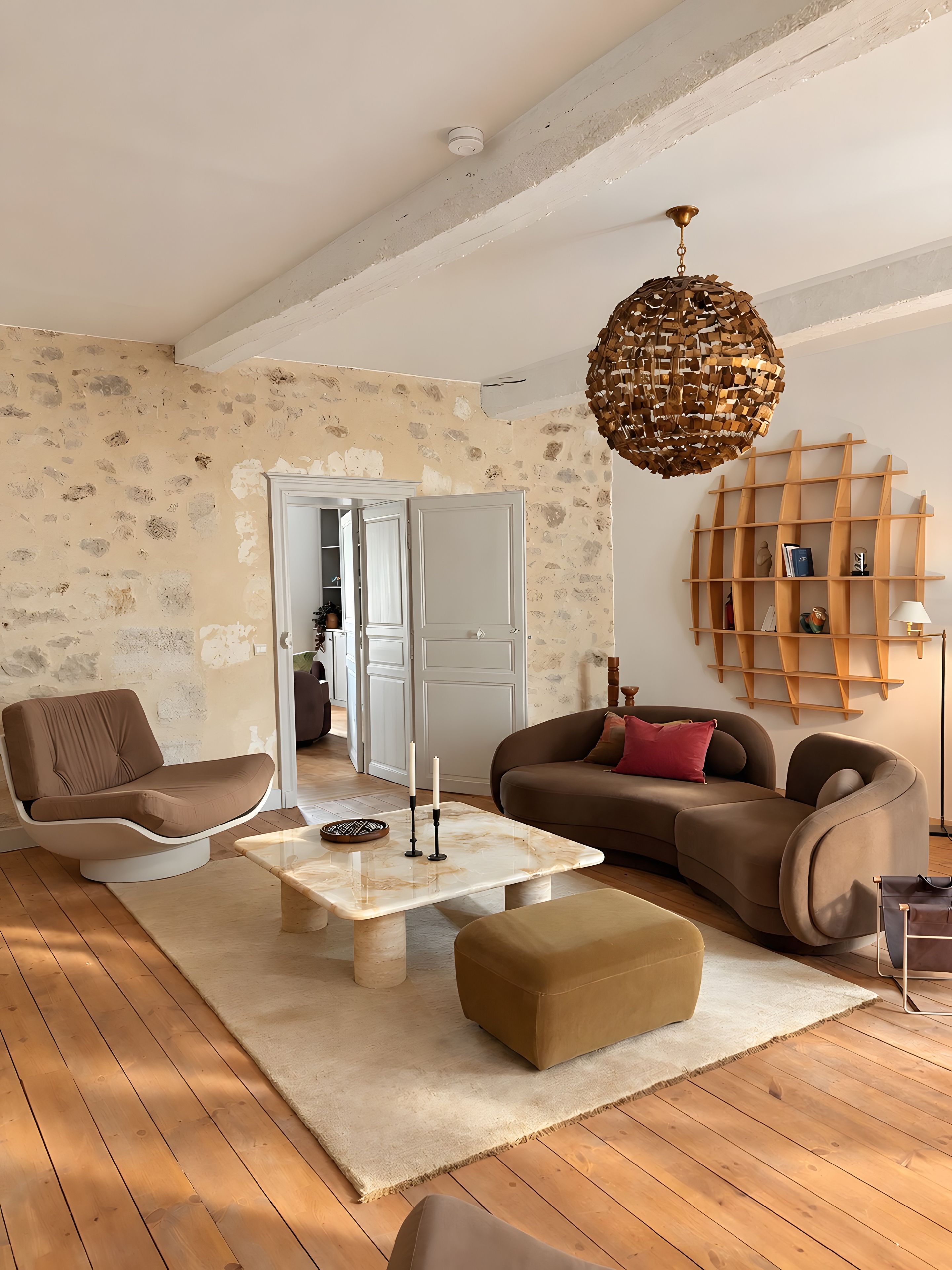 Una sala de estar moderna con un sofá, un sillón, una mesa de centro y una lámpara colgante original.