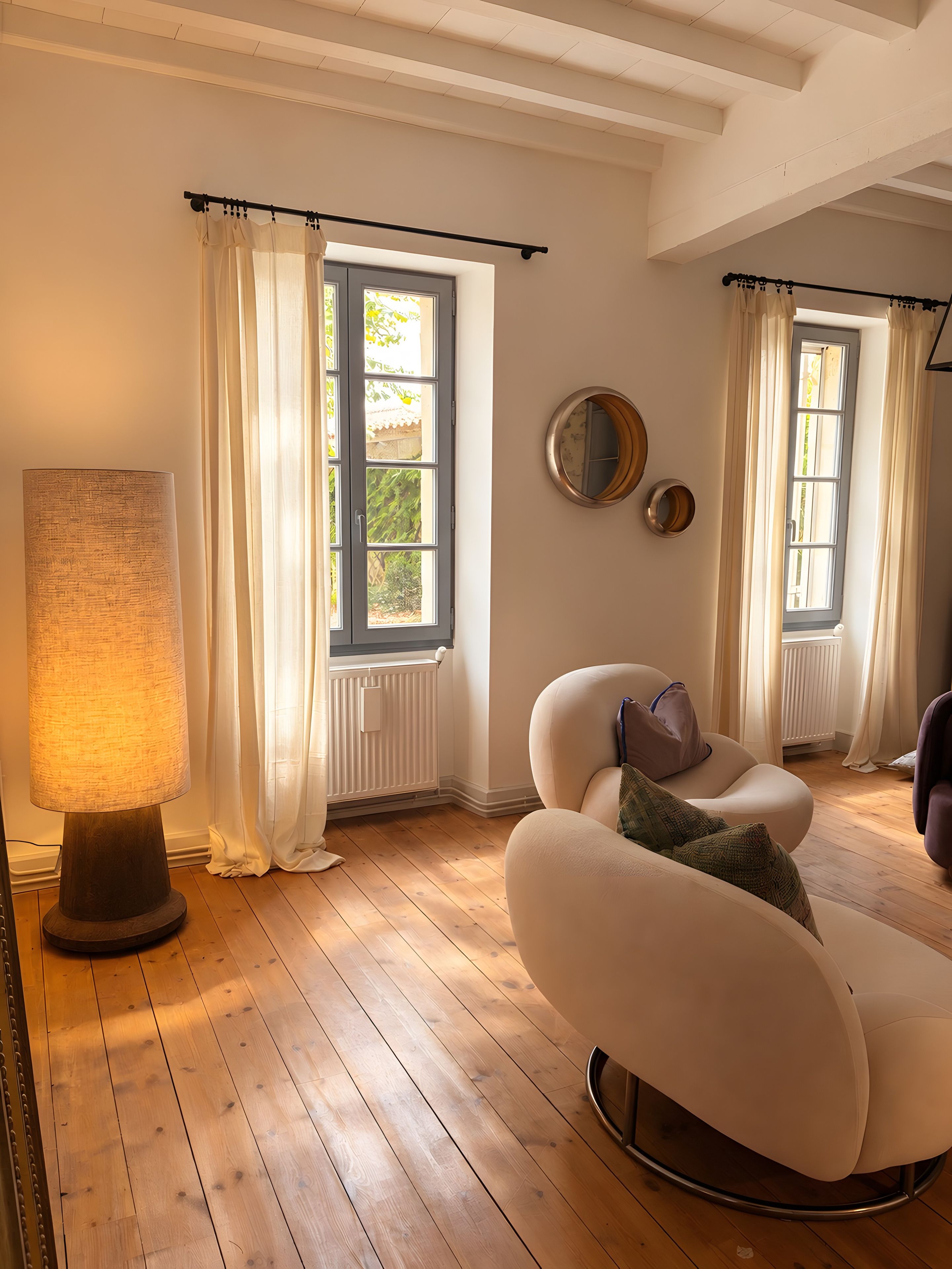 Una habitación con un ventanal grande, una lámpara de pie y un sofá moderno.