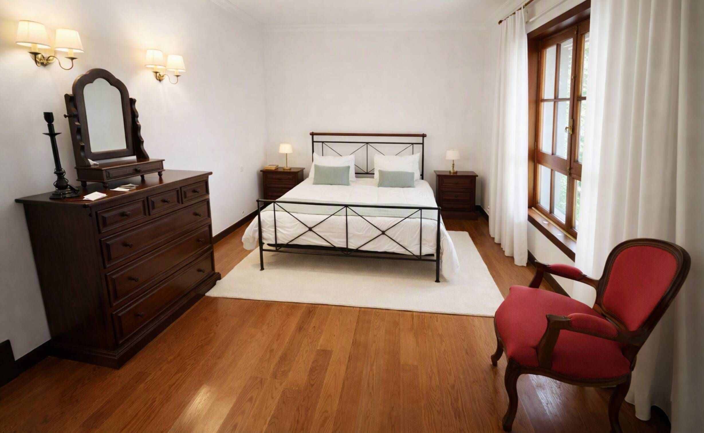 Une chambre à coucher avec un lit, une commode, une chaise et une fenêtre.