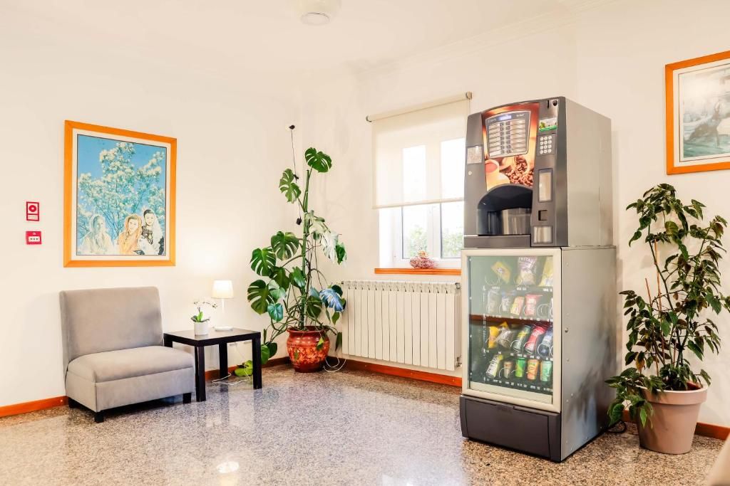 Una habitación con zona de estar, máquina expendedora y ventana.