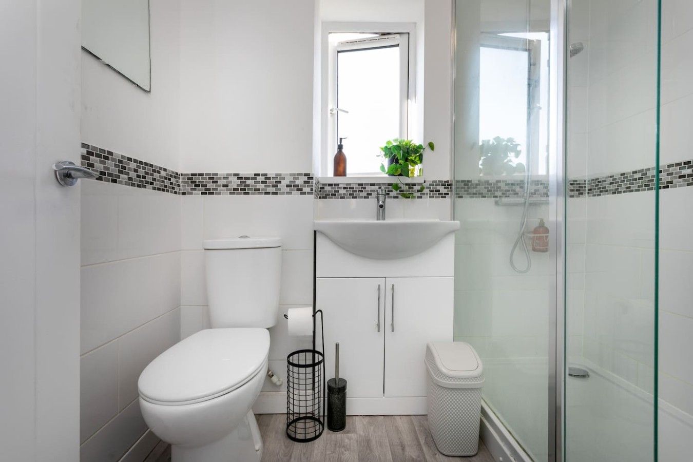Ein modernes Badezimmer mit Toilette, Waschbecken und Dusche.