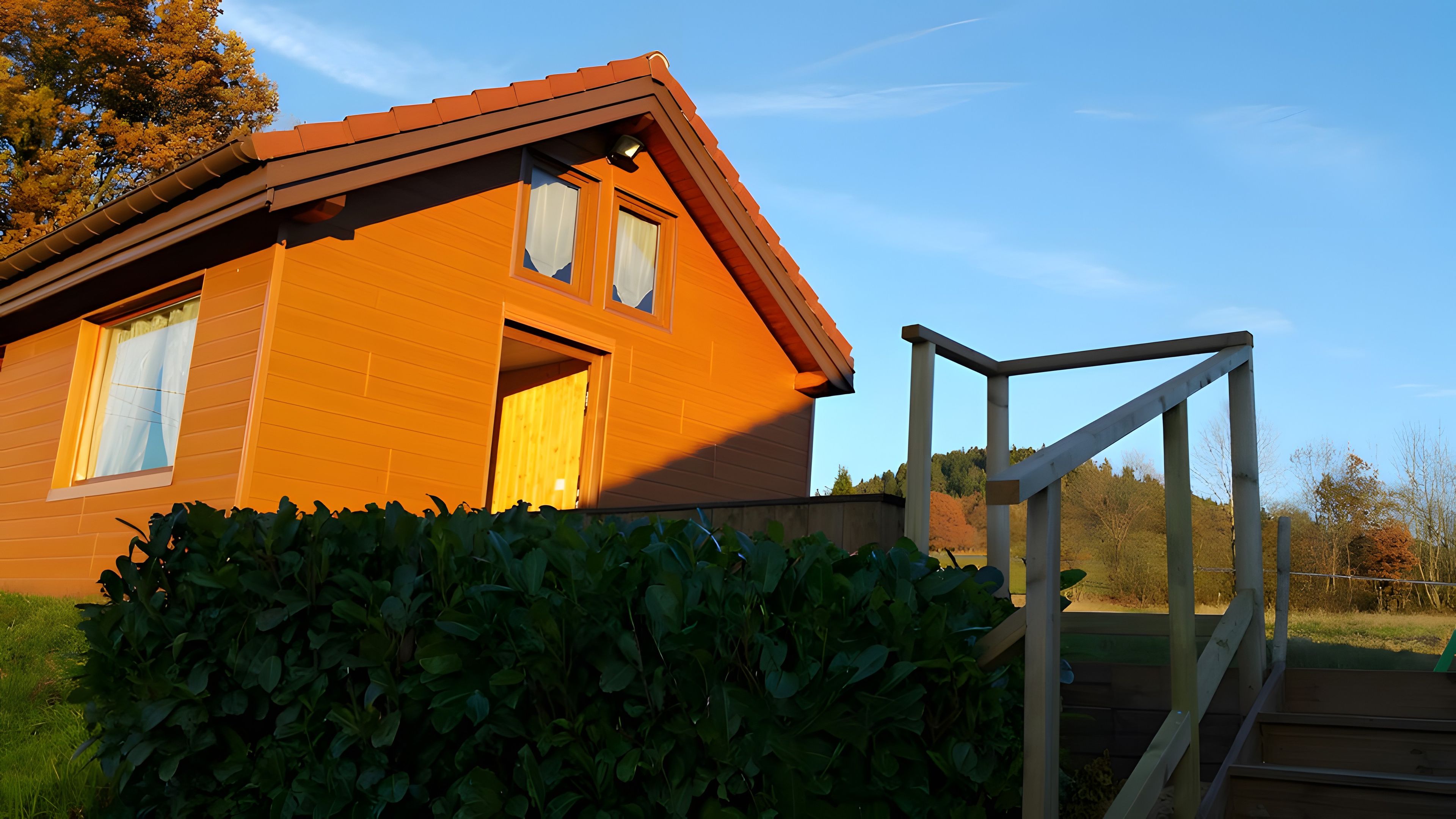 Ein Holzhaus mit geneigtem Dach, einer sichtbaren Tür und einem Fenster.