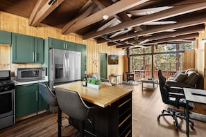 L’int érieur d’une cabane comprenant une cuisine, un coin repas et une cheminée.