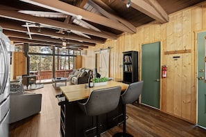 Un intérieur en bois comprenant un coin repas, des sièges et une cheminée.