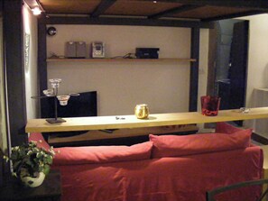 Ein Zimmer mit einem Bett, einem Schreibtisch, einer Pflanze und einem Fenster.
