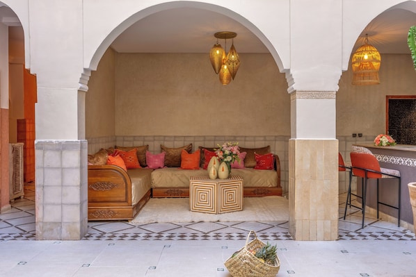 A cozy seating area with a sofa, pillows, and a decorative vase. - Dar Nouraï (Marrakech)