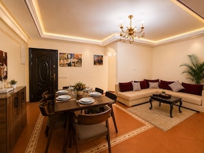 Un coin repas avec une table dressée pour quatre personnes, un canapé et une table basse.
