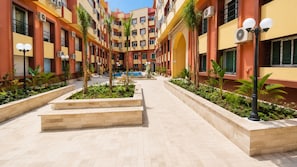 Un hôtel à plusieurs étages doté d’une cour intérieure, d’un espace extérieur aménagé et d’une piscine.