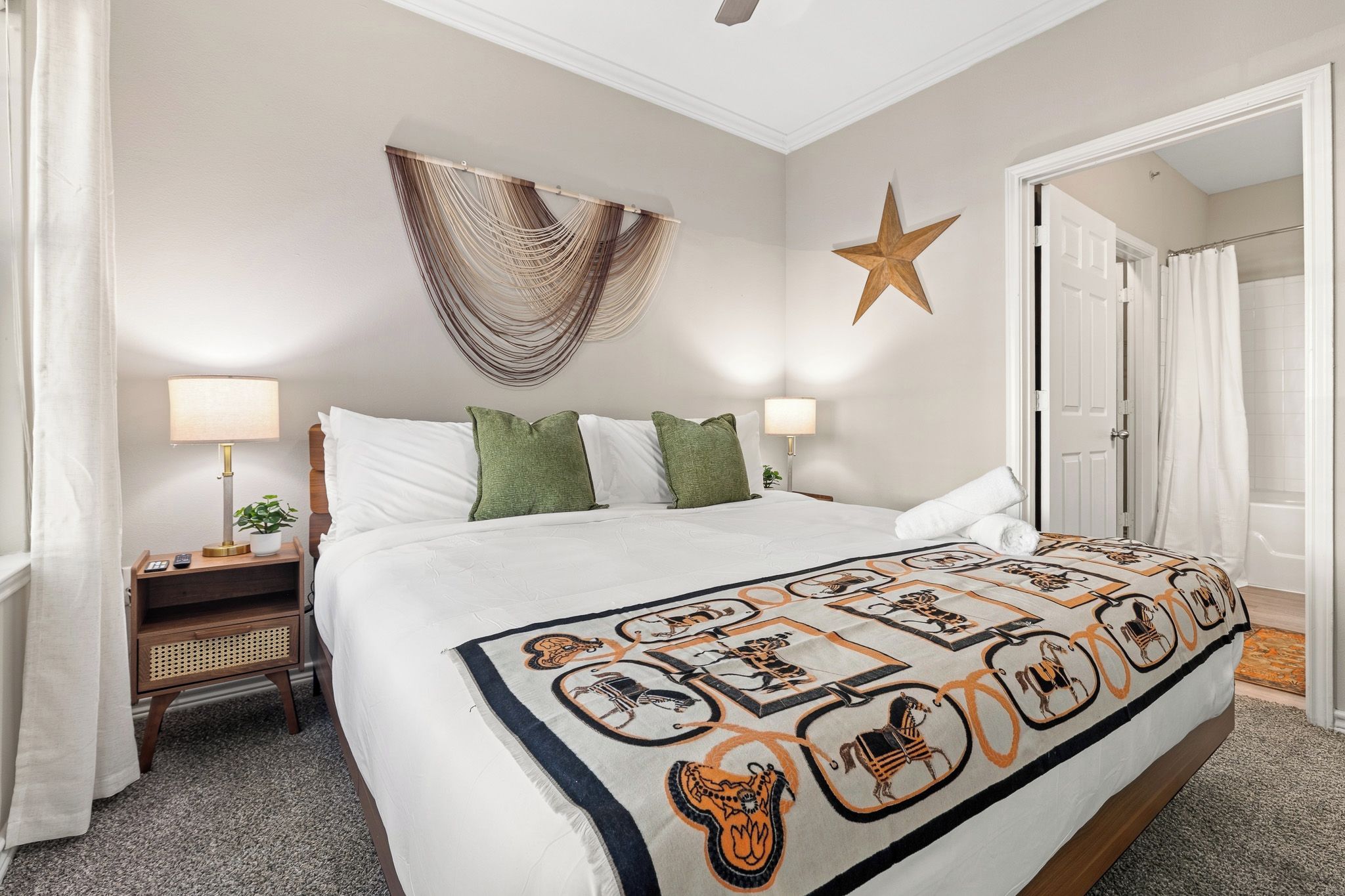 Ein Hotelzimmer mit einem großen Bett, zwei Nachttischen, einer Wanddekoration mit Sternen und einer Tür zu einem Badezimmer.