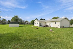 Ein Wohnhaus mit großem Rasen, Garage und Geräteschuppen.