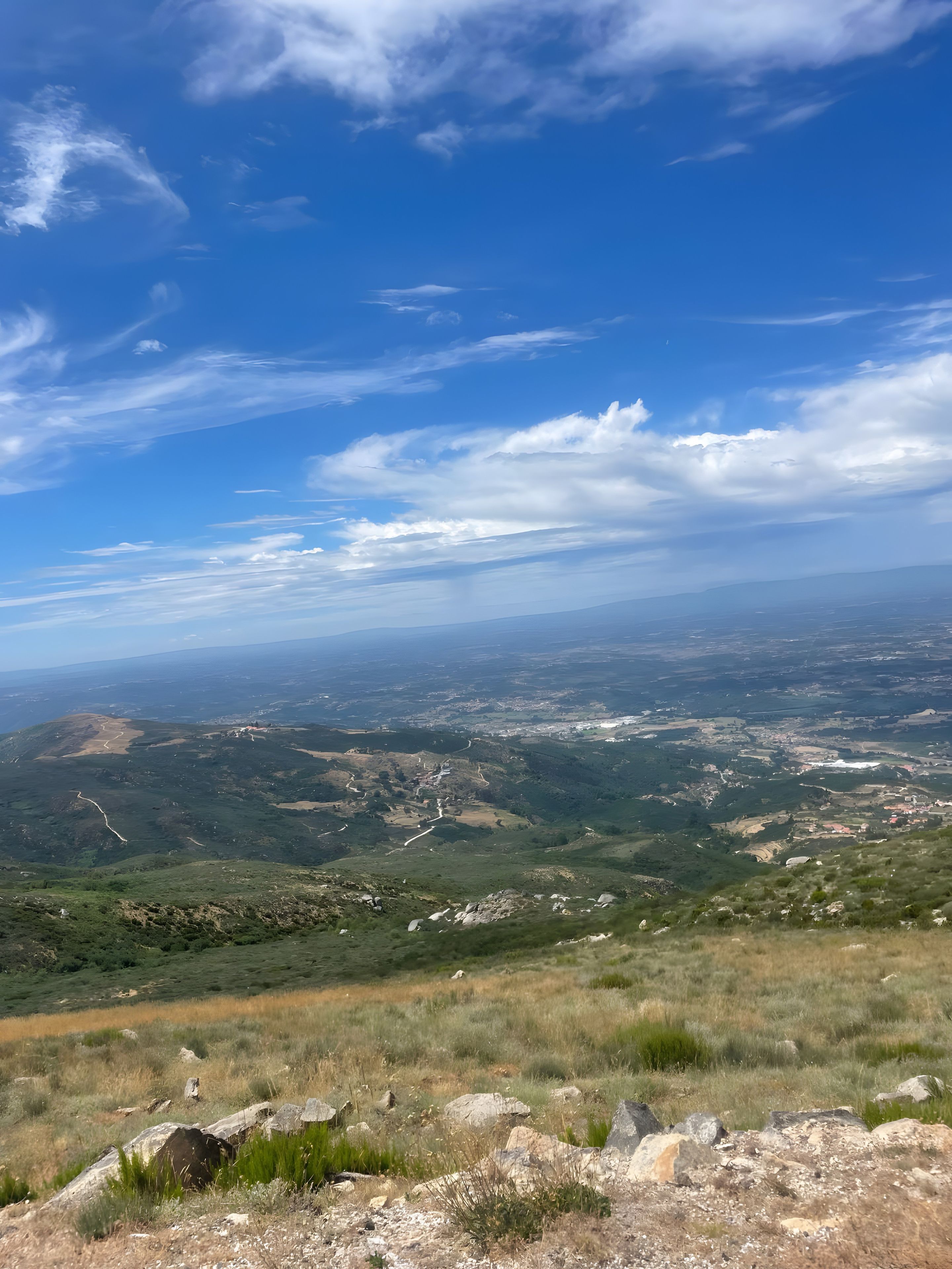 Et panorama over et bakket landskab under en klar himmel.