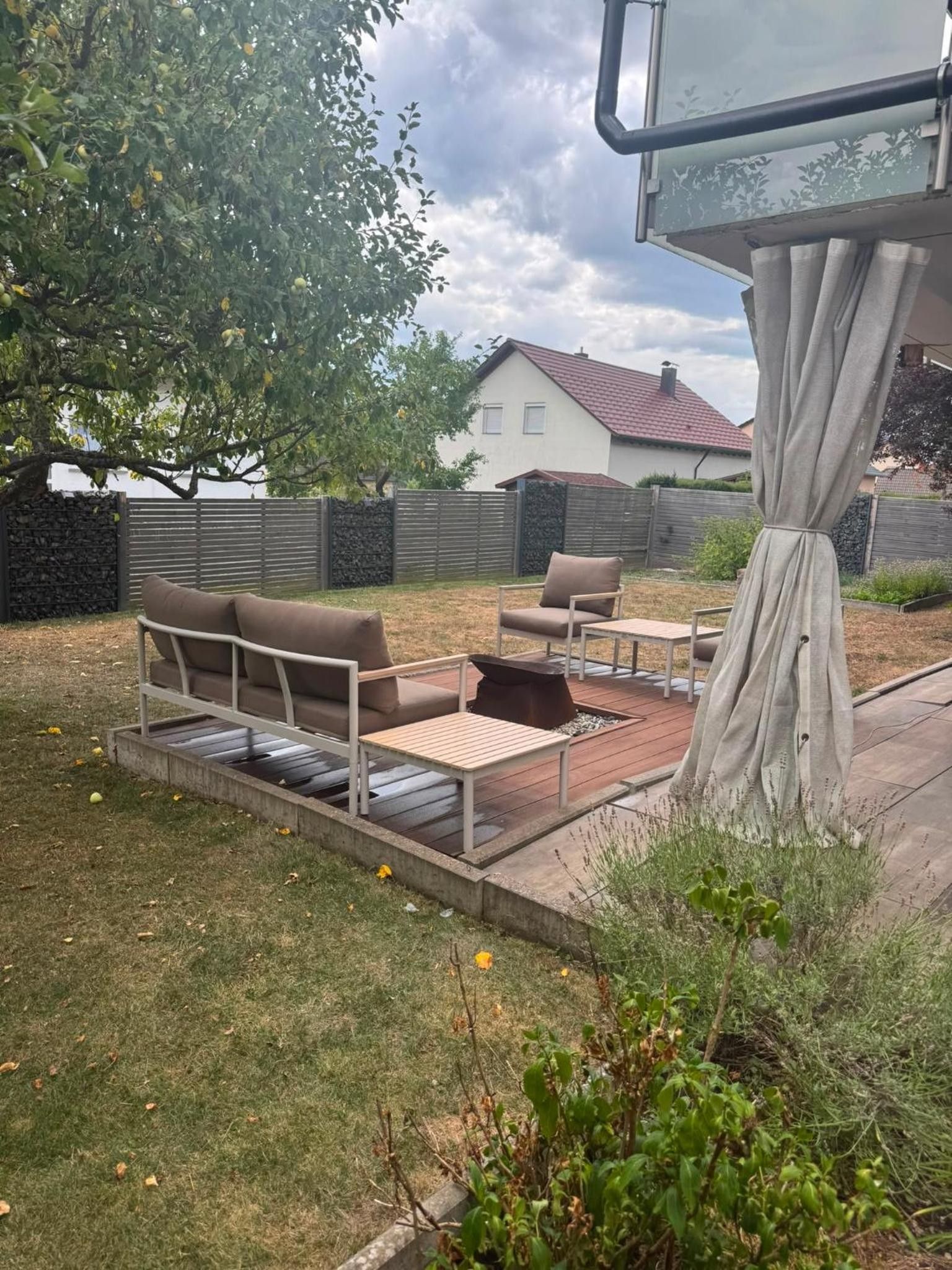 An outdoor patio area with a sofa, chairs, and a small table.