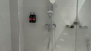 A modern shower with a handheld showerhead and a wall-mounted faucet.