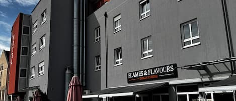 Un edificio con un restaurante llamado 'Flames & Flavours' en la planta baja.