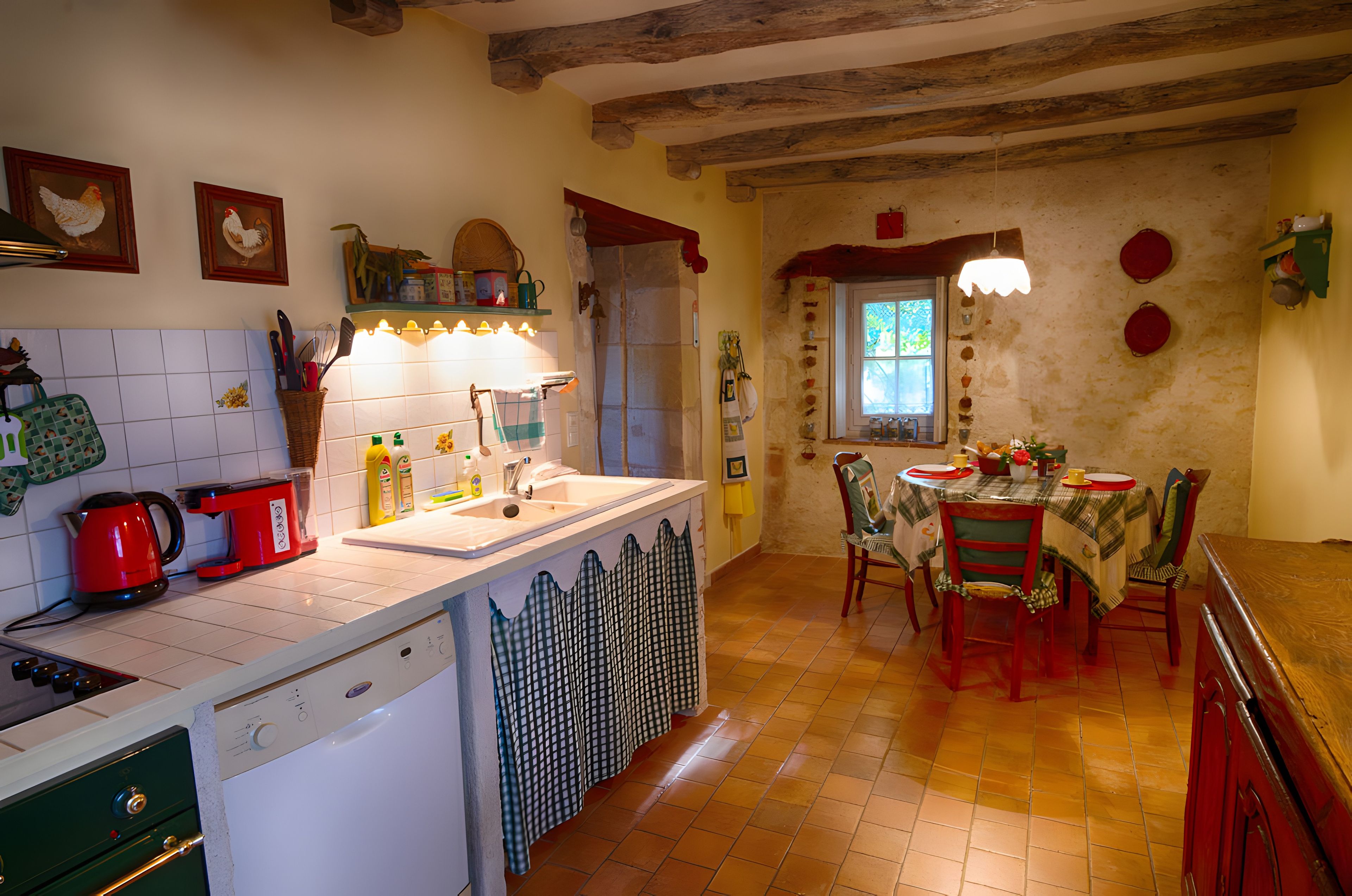 Une cuisine équipée d’un évier, d’une cuisinière et d’un coin repas avec des chaises et une table.