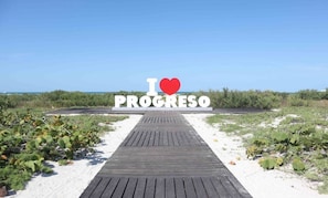 En træpromenade der fører hen til et skilt med 'I ♥ PROGRESO'.