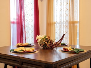 Mesa de comedor dispuesta con platos, servilletas y un centro de mesa.