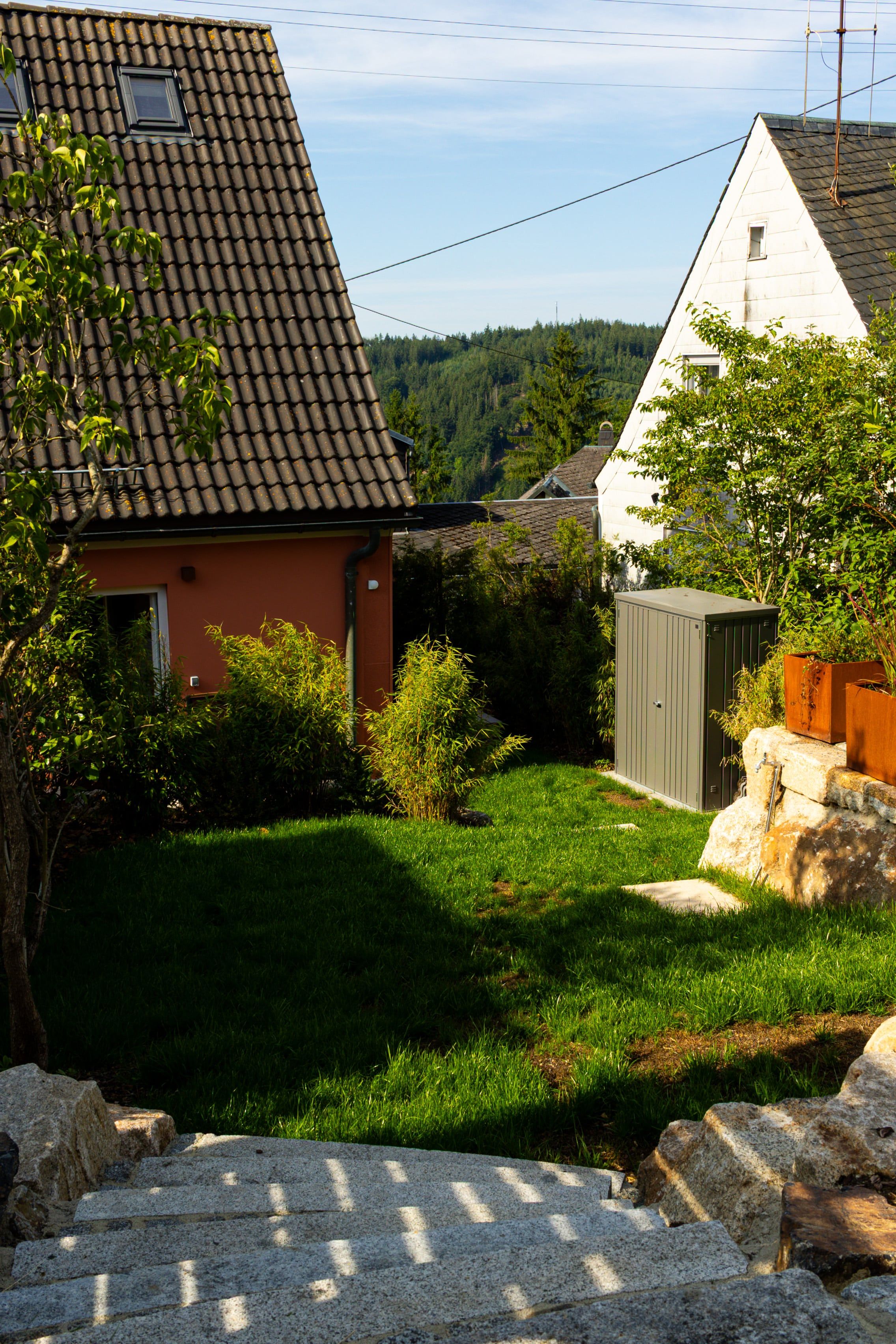 A residential area with a house featuring a tiled roof, a well-maintained lawn, and a small shed.