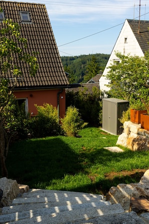 A residential area with a house featuring a tiled roof, a well-maintained lawn, and a small shed. - New Listing (Schwarzenbach am Wald)