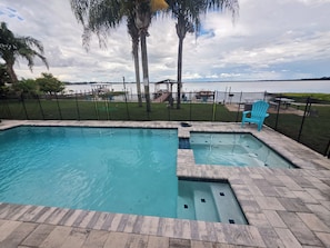 A swimming pool with a view of the lake and palm trees. - Lake Dora cabana with pool, hot tub and dock (Tavares)