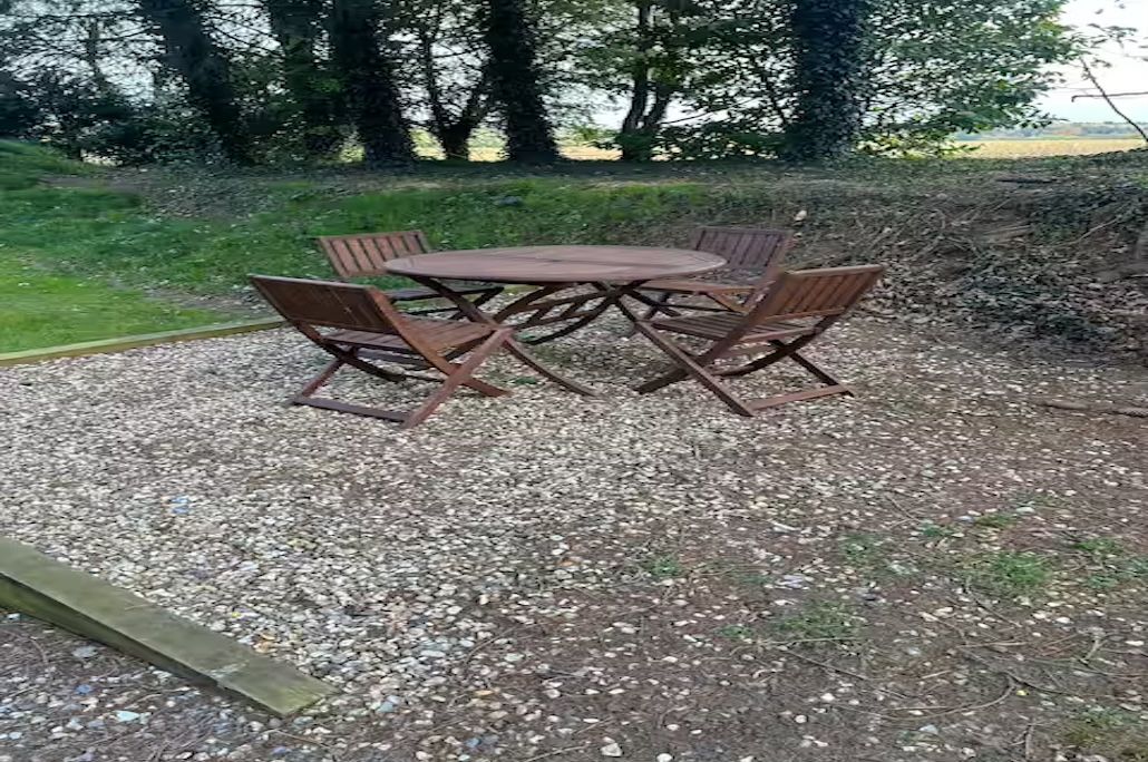 A round wooden table with four chairs in an outdoor setting.